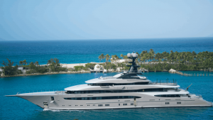 Superyacht on turquoise water by a beach.