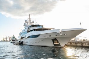 Superyacht at the harbour, the sun is reflected on the water