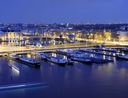 Amsterdam Marina at night with the street lights reflecting the yachts on the water