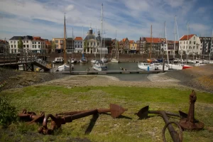 Vlissingen's old harbour with boats and small yachts docked in front of a row of houses.